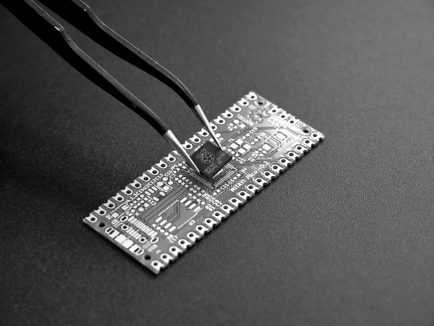 Tweezers placing a small chip onto a circuit board